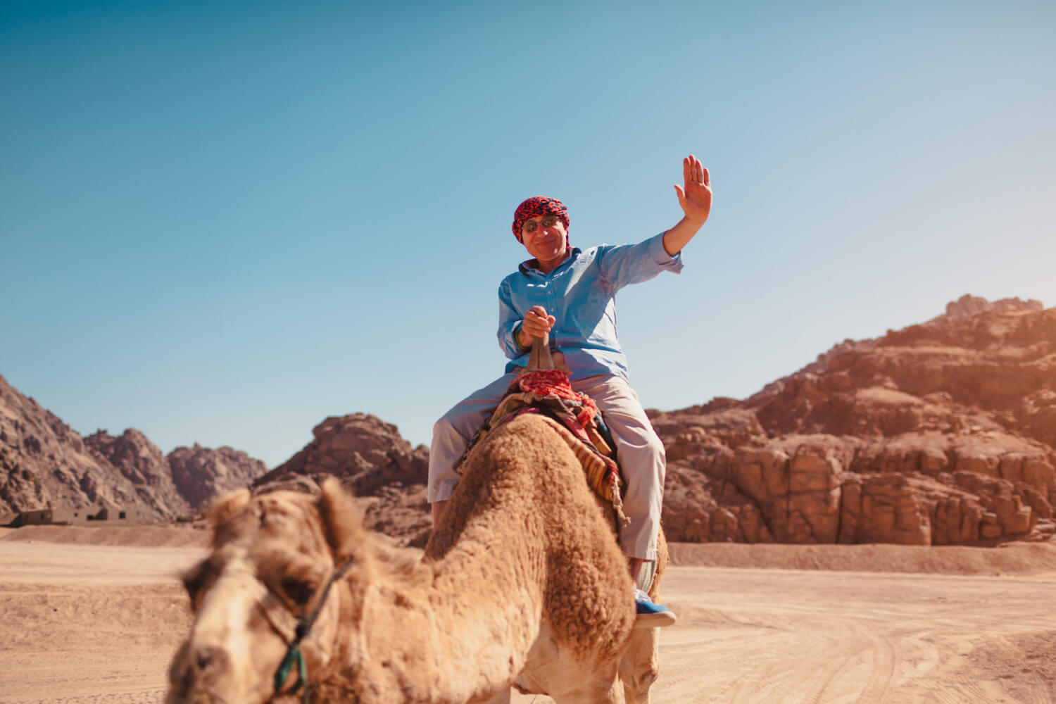 senior-man-rides-camel-desert-by-sinai-mountains (1)